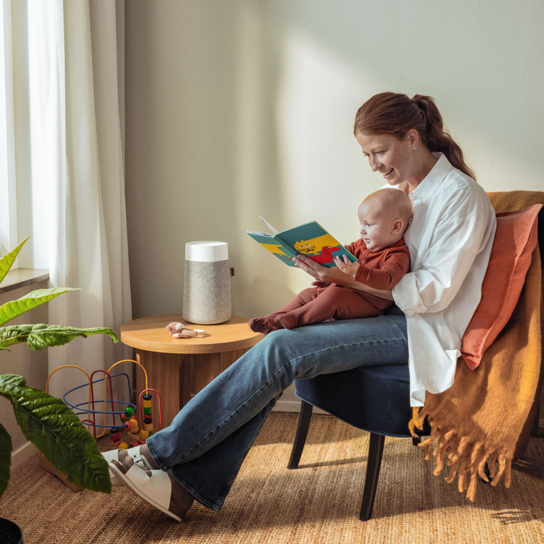Blueair Woman with child in nursery reading with air purifier in back